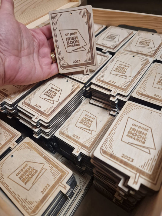 Laser-cut wooden award tag in progress on CNC machine